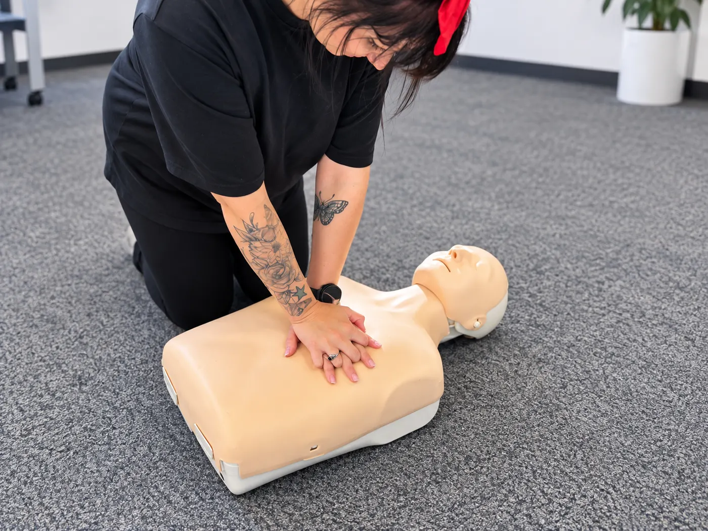 A trainer showing CPR technique on a manikin