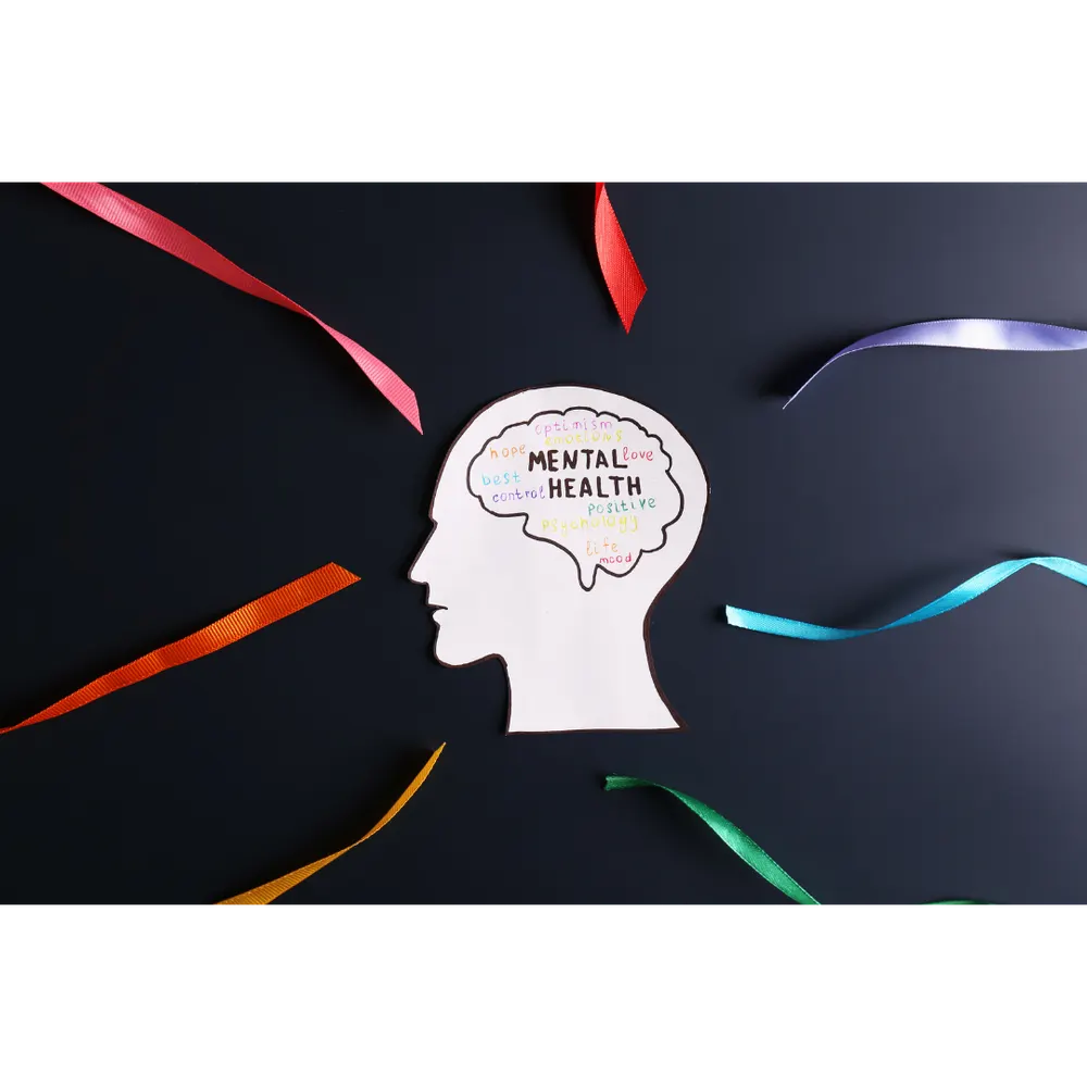 A paper head with coloured ribbons and the words mental health